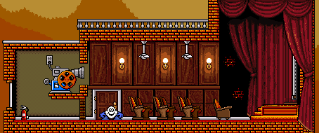 Projection room with red curtains and theatre seats.